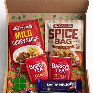Può includere: Una confezione regalo a forma di cassetta delle lettere contenente generi alimentari. Include bustine di salsa al curry delicata e condimento Spice Bag di McDonnell's, bustine di tè Barry's Tea Gold, barrette di cioccolato Cadbury Dairy Milk e Twirl e un portachiavi a forma di quadrifoglio verde.