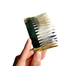 Peine lateral de cuerno elaborado a mano con dientes ondulados.