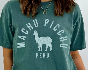 May include: A teal blue t-shirt with a white graphic of an alpaca and the text "Machu Picchu" and "Peru".