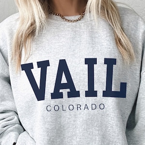 May include: Gray sweatshirt with a navy blue "VAIL COLORADO" graphic.