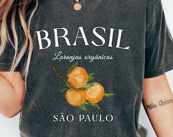 Puede incluir: Una camiseta gris con un diseño gráfico blanco que dice "BRASIL" con una rama de naranjas y el texto "Laranjas orgânicas" y "SÃO PAULO".