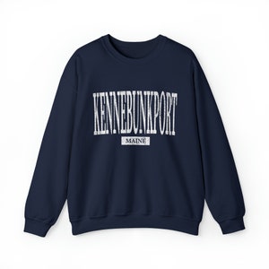 K&ouml;nnte beinhalten: Ein marineblaues Sweatshirt mit dem wei&szlig;en Schriftzug "KENNEBUNKPORT" in einem Bogen &uuml;ber der Brust. Darunter steht das Wort "MAINE" in einem kleineren wei&szlig;en Rechteck. Das Sweatshirt hat einen Rundhalsausschnitt.