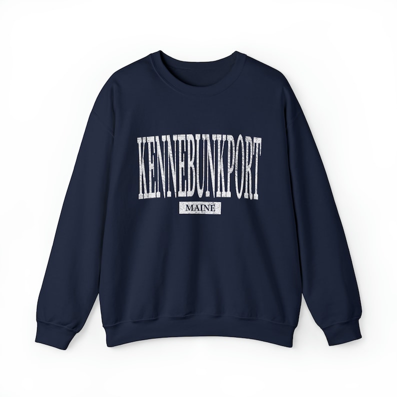 K&ouml;nnte beinhalten: Ein marineblaues Sweatshirt mit dem wei&szlig;en Schriftzug "KENNEBUNKPORT" in einem Bogen &uuml;ber der Brust. Darunter steht das Wort "MAINE" in einem kleineren wei&szlig;en Rechteck. Das Sweatshirt hat einen Rundhalsausschnitt.