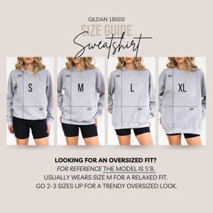 May include: A Gildan 18000 sweatshirt size guide showing four gray sweatshirts in sizes S, M, L, and XL. Each displays length and width measurements in inches. Text includes: LOOKING FOR AN OVERSIZED FIT? FOR REFERENCE THE MODEL IS 5'8.