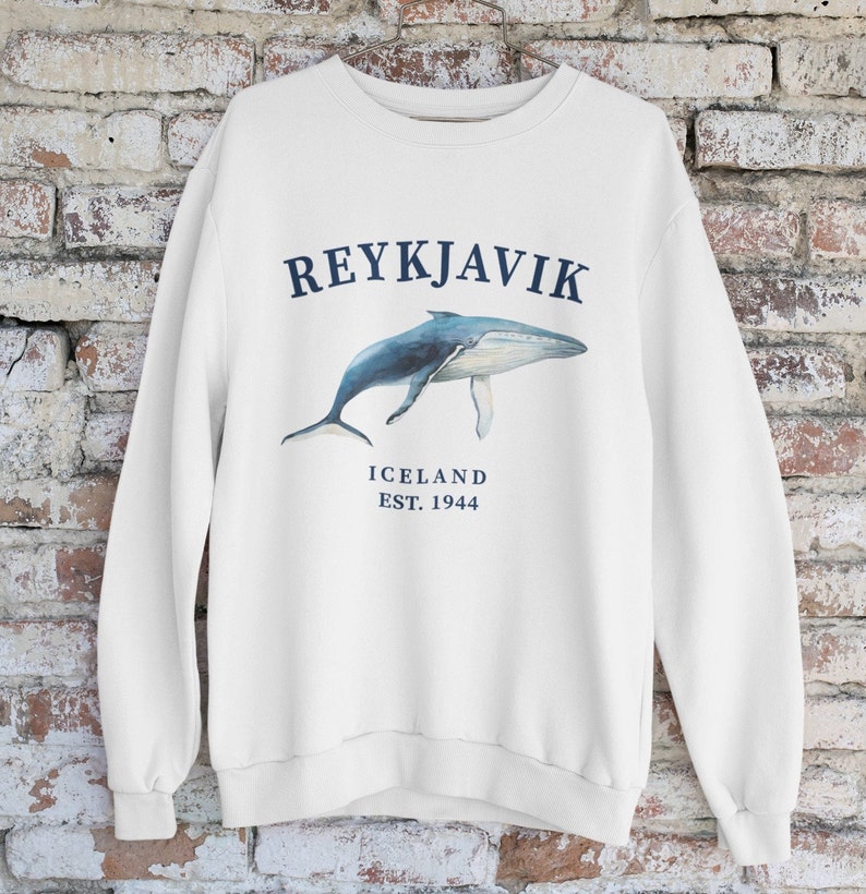 May include: White sweatshirt with a blue whale graphic and the text "REYKJAVIK ICELAND EST. 1944"