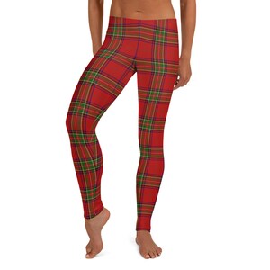 May include: Full-length leggings featuring a vibrant red base color with a classic tartan plaid pattern. The design incorporates intersecting thin lines in shades of forest green, navy blue, and golden yellow, creating a repeating grid across the fabric.