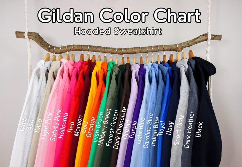 Puede incluir: Una carta de colores Gildan para sudaderas con capucha que muestra una fila de sudaderas de varios colores colgadas de una rama de madera. El texto dice Gildan Color Chart Hooded Sweatshirt, con etiquetas para cada color, incluyendo White, Ash, Sand, Light Pink, Safety Pink, Heliconia, Red, Maroon, Gold, Orange, Irish Green, Military Green, Forest Green, Dark Chocolate, Orchid, Purple, Light Blue, Carolina Blue, Indigo Blue, Royal, Navy, Sport Gray, Dark Heather y Black.