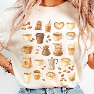 Op de afbeelding: Crèmekleurige sweatshirt met een aquarelontwerp van diverse koffiegerelateerde items. Het ontwerp bevat koffiebonen, kopjes, een hartvormige latte, een koffiezak en een koffiezetapparaat. Het algemene thema is koffie en cafécultuur.