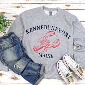 May include: Gray sweatshirt with a red lobster graphic and the text "Kennebunkport Maine".