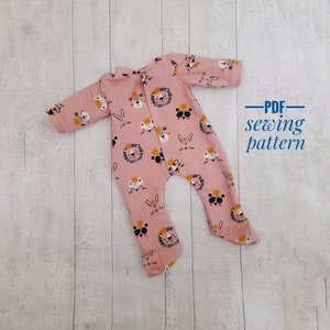 May include: A pink baby onesie with a print of various animals wearing crowns. The onesie has long sleeves and poppers at the crotch. The text "PDF sewing pattern" is written in blue on a white background.