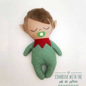 May include: A plush elf doll with brown hair, closed eyes, and a green pacifier. The elf is wearing a green and white striped outfit with a red collar. The text "COMBINE WITH THE add ons patterns SOLD SEPARATELY" is at the bottom of the image.