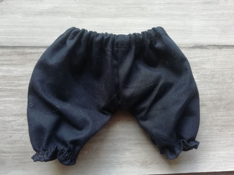 Puede incluir: Bragas de beb&eacute; azul oscuro con cintura el&aacute;stica y dobladillos con volantes. Estos pantalones cortos suaves y fruncidos est&aacute;n hechos de una tela de color s&oacute;lido. Las bragas est&aacute;n dise&ntilde;adas para beb&eacute;s y ni&ntilde;os peque&ntilde;os.
