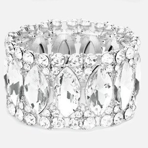 May include: A silver bracelet with a row of large, clear, faceted crystals. The crystals are set in a silver band and are arranged in a staggered pattern.
