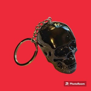 medium sized black resin skull keychain with silver foil
