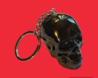 medium sized black resin skull keychain with silver foil