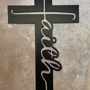 Peut inclure: Croix en m&eacute;tal noir avec le mot "foi" &eacute;crit en cursive sur la poutre verticale.