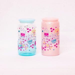 May include: Two glass tumblers with lids, one blue and one pink, are displayed. Each tumbler features a science-themed design with hearts, beakers, and the text "Carry yourself with the confidence of a mediocre white man."