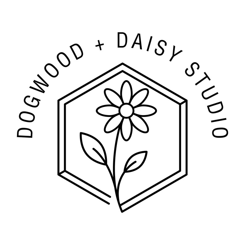 Może przedstawiać: Czarno-białe logo dla Dogwood + Daisy Studio. Logo przedstawia kwiat stokrotki wewnątrz sześciokąta. Słowa "Dogwood + Daisy Studio" są wygięte wok&oacute;ł sześciokąta.