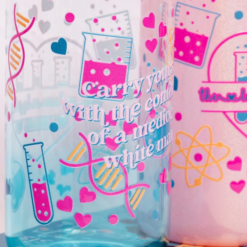 May include: Two clear water bottles with science-themed graphics. One bottle is light blue, the other is pink. Both feature pink hearts, DNA strands, and text that reads "Carry your with the confidence of a mediocre white man."
