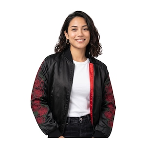 May include: Black bomber jacket with red rose embroidery on the sleeves. The jacket has a red lining and a black ribbed collar and cuffs. The model is wearing a white t-shirt and black jeans.