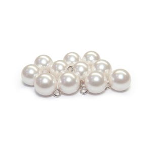 May include: A collection of luminous, round, white pearls with small silver loops attached. The pearls are clustered together against a white background, showcasing their smooth, reflective surfaces. These are likely jewelry components.