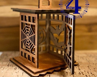 Peut inclure: Une lanterne d'Halloween en bois avec un motif de toile d'araignée, une silhouette de sorcière et une silhouette de chauve-souris. La lanterne a une porte à charnières et un petit toit avec un fleuron.