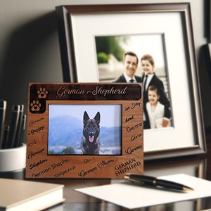 May include: A wooden picture frame with a photo of a German Shepherd dog. The frame is engraved with the words "German Shepherd" and the phrase "a Shepherd herd".