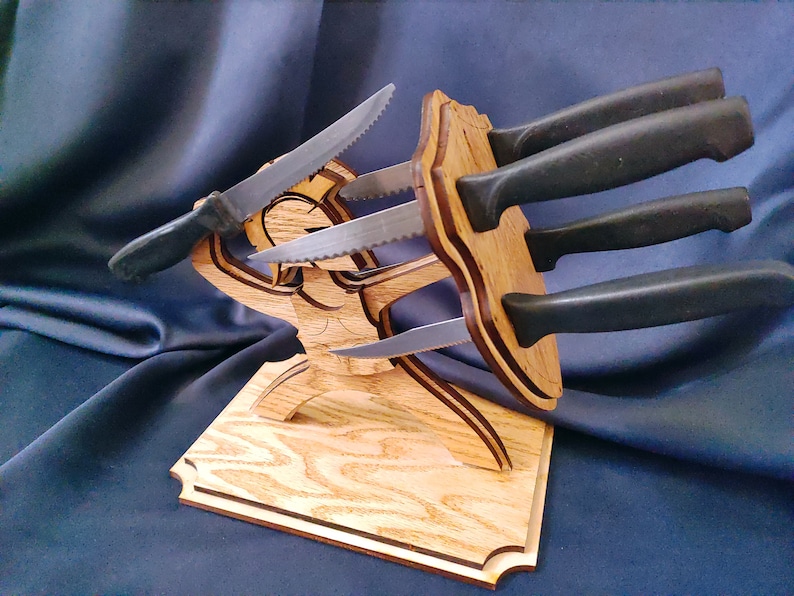 May include: Wooden knife holder shaped like a person holding a shield, with four knives inserted into the holder.
