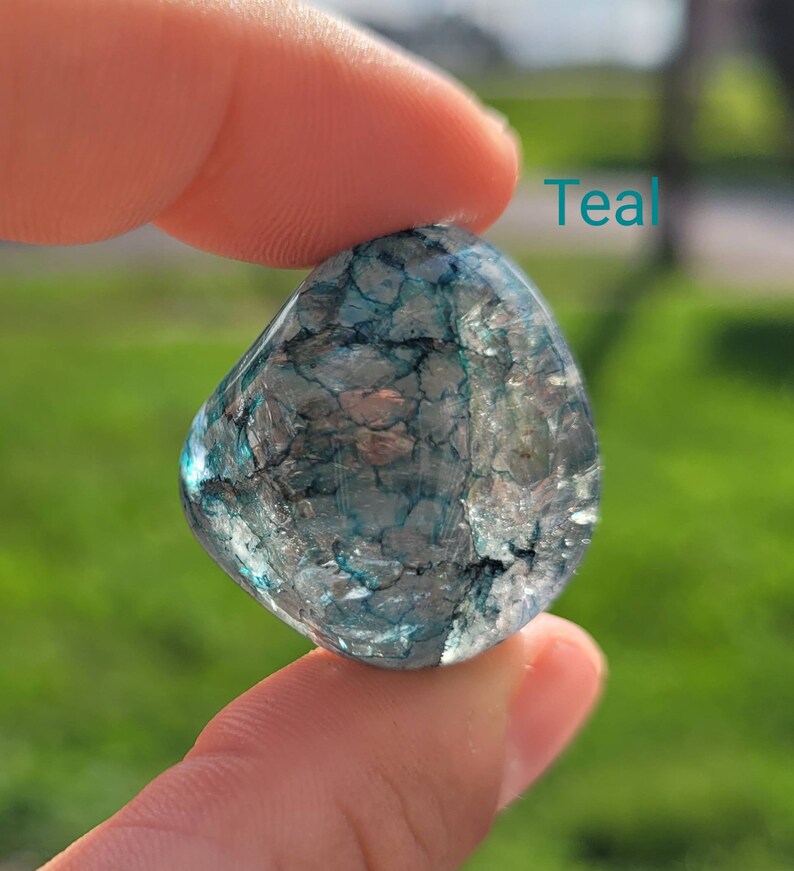 May include: Teal crystal with a clear, translucent appearance and a swirling, marbled pattern of dark blue and green.