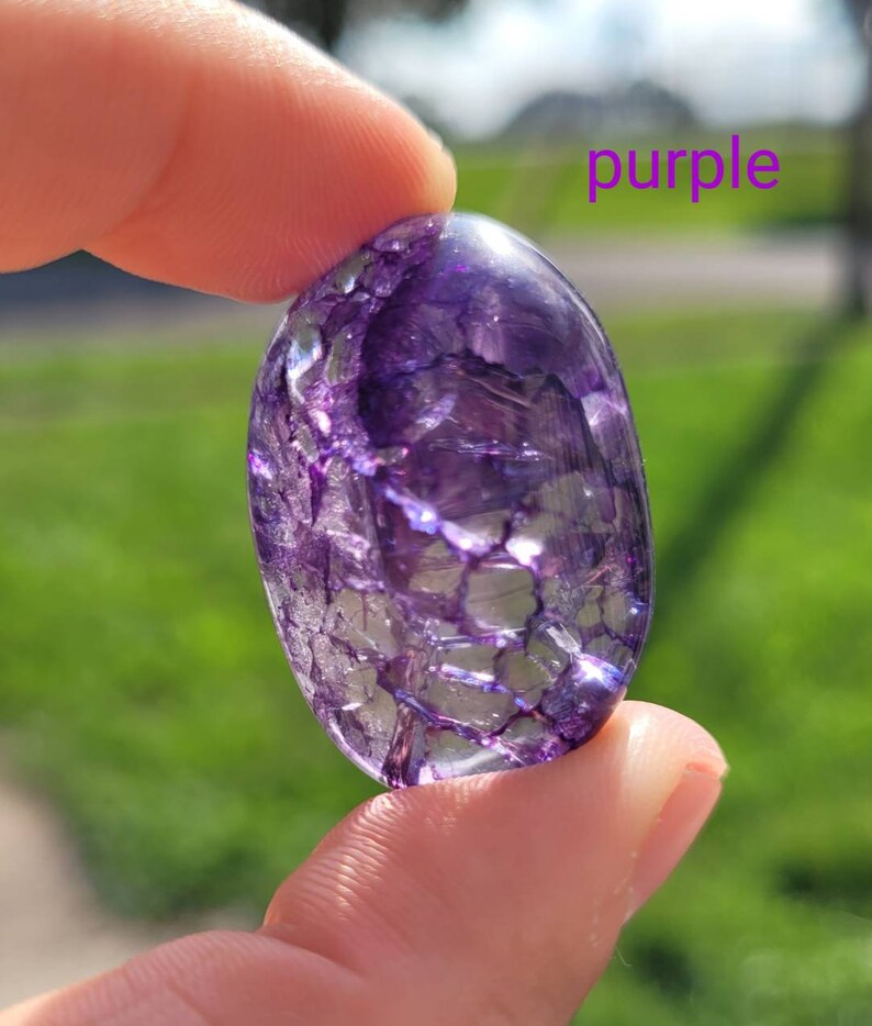May include: A purple crystal with a unique, intricate pattern of white veins. The crystal is smooth and polished, with a slightly oval shape.