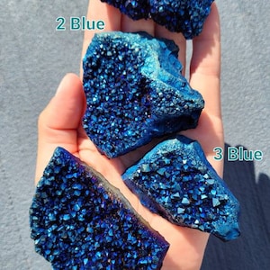 May include: Four blue iridescent crystal clusters, labeled 1 Blue, 2 Blue, 3 Blue, and 4 Blue, are displayed in a hand.
