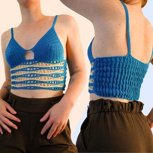 Op de afbeelding: Een blauwe en beige gehaakte crop top met dunne schouderbandjes, een V-hals met een kleine ronde uitsparing en een middengedeelte met horizontale golvende strepen in afwisselend blauw en beige garen, voorzien van een geribbeld achterpand.