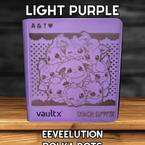 Może przedstawiać: Jasnofioletowy 12-stronicowy standardowy segregator TCG z wzorem "EEVEELUTION POLKA DOTS". Segregator posiada wzór postaci z kreskówek oraz napis "vaultx Chibicat surprise". Na górze segregatora znajduje się napis "A & T" oraz "12 PAGE STANDARD TCG BINDER LIGHT PURPLE".