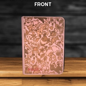May include: A pink card binder with a repeating pattern of cartoon characters. The word "Vault X" is printed on the lower left corner. The text "THIS DESIGN WILL BE ON THE FRONT" is printed at the top.