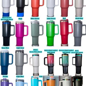 May include: A collection of insulated travel mugs in various colors, including white, black, orange, pink, green, red, and gray. Each mug has a handle and a lid. Some mugs have plated accents in blue, rainbow, or gold.