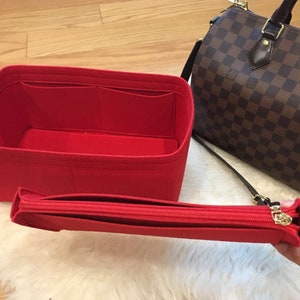 May include: Red felt bag organizer with multiple compartments and a zippered pouch. The organizer is designed to fit inside a larger bag.