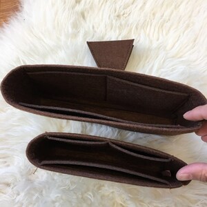 May include: Two brown felt bag organisers with multiple compartments. The larger organiser has a triangular flap on top.