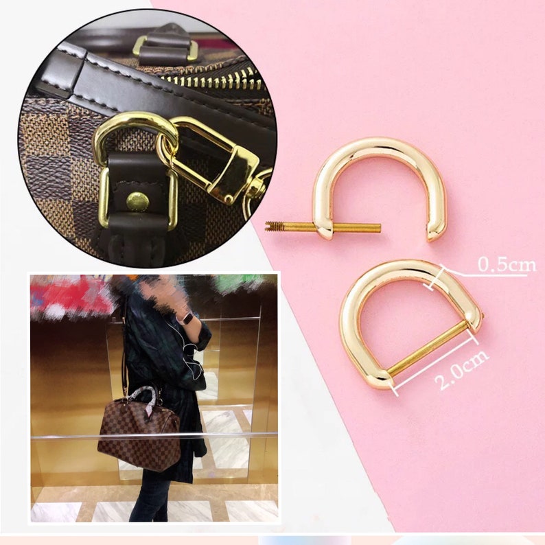 May include: Two gold-toned metal D-rings with a screw closure. The rings are 2 cm long and 0.5 cm wide.