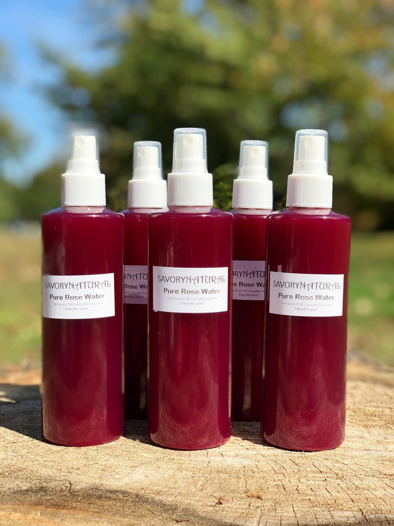 May include: Five clear glass bottles with white spray tops filled with a deep red liquid. The bottles are labelled "Savory Natural Pure Rose Water".