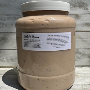 May include: A large, clear plastic jar filled with a beige, speckled hair mask. The white label reads Chebe & Henna Hair Mask with Irish Sea Moss, Growth Support & Moisture Retention, along with directions, ingredients, and contact information.