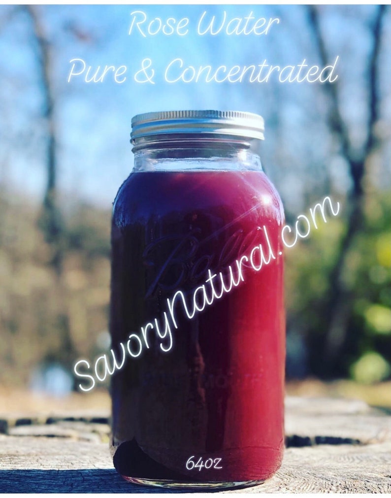 May include: A glass jar filled with a deep red liquid, labelled "Rose Water Pure & Concentrated" and "SavoryNatural.com". The jar has a silver lid and is sitting on a wooden surface. The jar is labelled with "64oz".