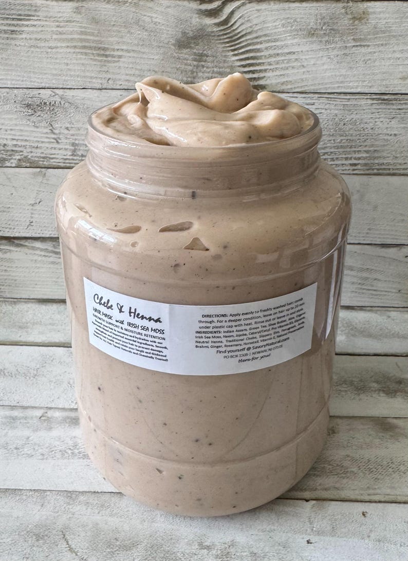 May include: A large clear plastic jar filled with a thick beige hair mask containing visible dark specks. The label reads Chebe & Henna Hair Mask with Irish Sea Moss, Growth Support & Moisture Retention, including directions, ingredients, and contact information.