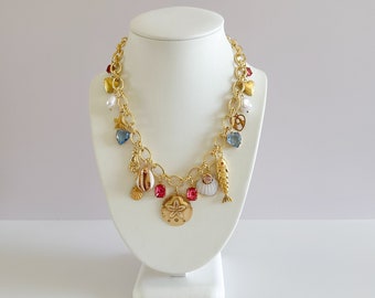 Collana con ciondoli vintage placcati in oro La Playa / Ciondoli in ottone grezzo con medaglione a cuore, pietra preziosa rosa, dollaro di sabbia, pesce costiero