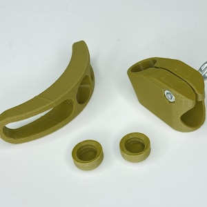 May include: A set of four olive green 3D printed plastic parts for a DIY project. The set includes two curved pieces, one with a hole and one with two holes, a rectangular piece with a hole and a small loop, and two round pieces.
