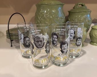 Könnte beinhalten: Vier klare Glasbecher mit Schwarzweißfotos von Footballspielern und dem aufgedruckten Text "Super Bowl XIII Pittsburgh vs Dallas". Die Gläser stehen auf einer weißen Oberfläche.