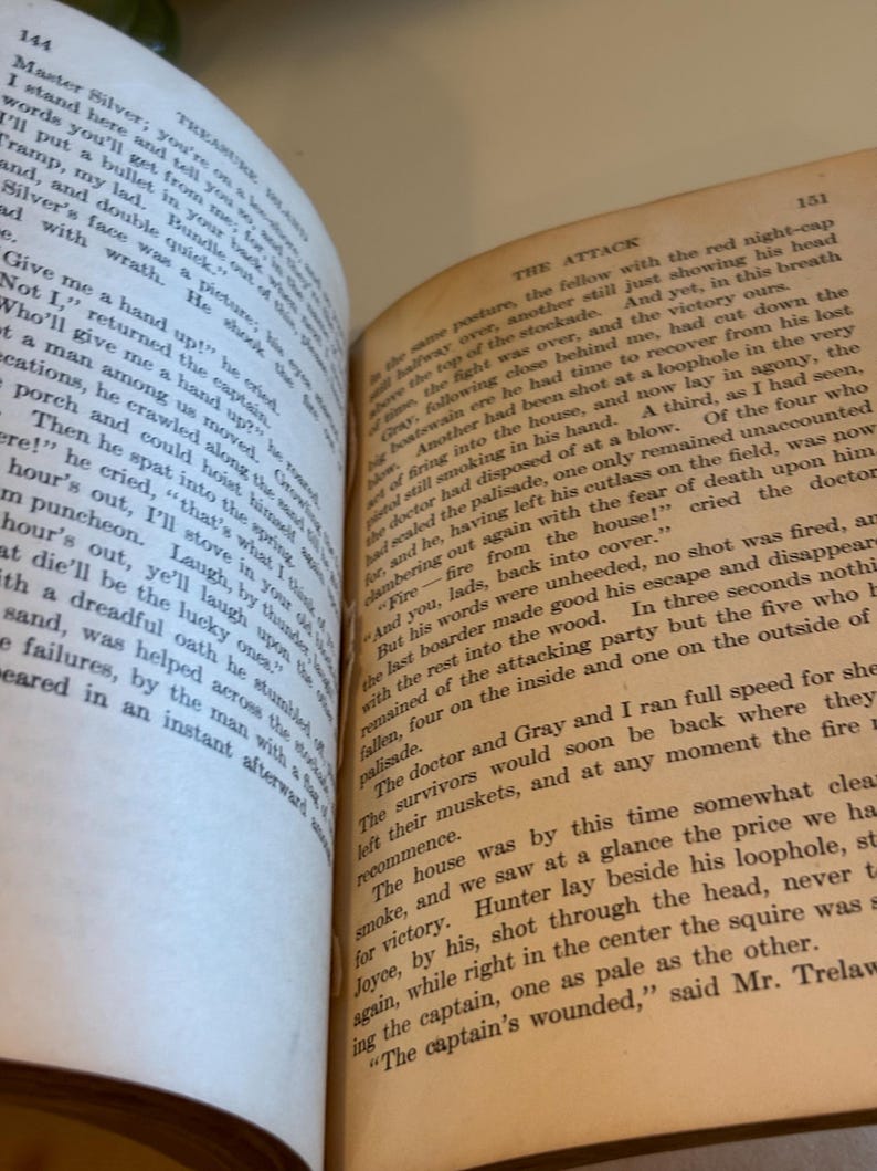 May include: Open pages of an antique book with text. The text is in English and appears to be from a novel. The pages are yellowed with age, and the book is open to a double-page spread.