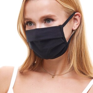 May include: A person wearing a black face mask with a white tank top and a gold necklace.
