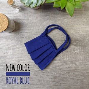 May include: A royal blue face mask with two straps. The mask is pleated and made of a soft, breathable fabric. NEW COLOR ROYAL BLUE