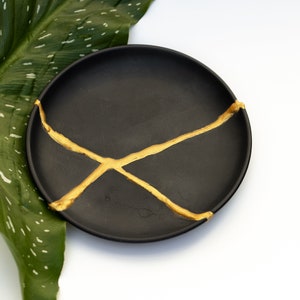 Svart Kintsugi-tallrik - Klockhållare - Heminredning - Smyckesbehållare - Guldreparation - Kintsugi-klockbricka - Kintsugi-keramik - Wabi Sabi-skål