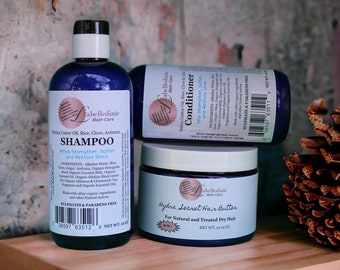 May include: Three blue bottles of hair care products: a shampoo, a conditioner, and a hair butter. The bottles are labelled "Cabelledinie Hair-Care" and list ingredients including Haitian Castor Oil, Rice, Clove, and Ambunu. The shampoo bottle says "Helps Strengthen, Soften and Restore Shine". The conditioner bottle says "Help Strengthen, Soften and Restore Shine". The hair butter bottle says "Hydra Secret Hair Butter" and "For Natural and Treated Dry Hair".